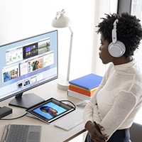 Woman listening to music while observing desktop applications